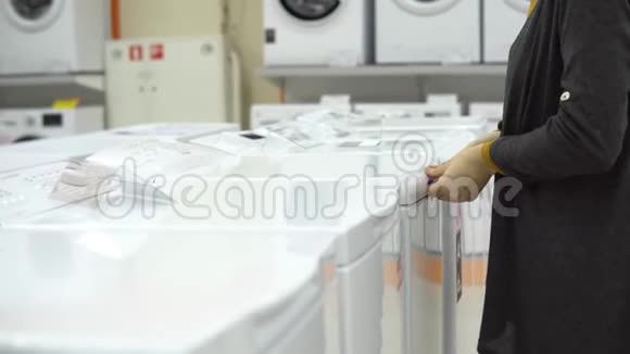 一位年轻女子在家电店里挑选洗衣机视频的预览图