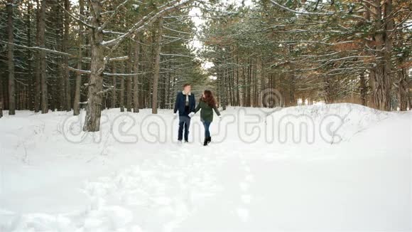 美丽的一对年轻人美丽的幸福夫妇在森林里散步男人拥抱女孩视频的预览图