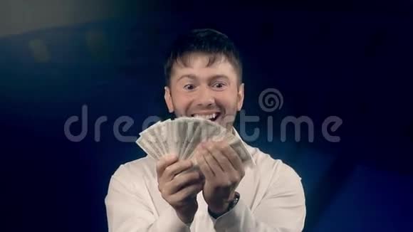 手里拿着许多钞票的快乐兴奋的男人视频的预览图