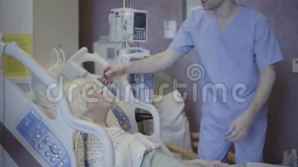 男护士帮助年长病人舒适视频的预览图