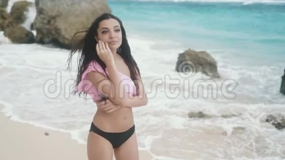 慢镜头穿着泳装的快乐女孩的肖像在海滩上放松背景是美丽的波浪Stealicam镜头视频的预览图
