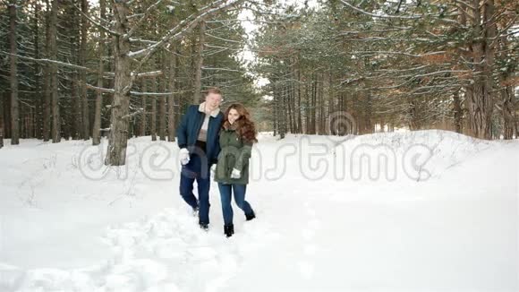 美丽幸福的情侣相爱在森林里散步男人拥抱女孩年轻人在冬天出去散步视频的预览图