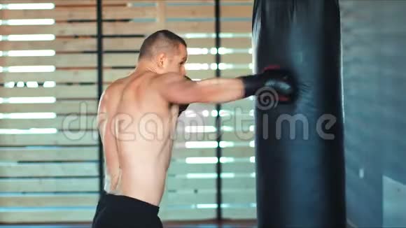 年轻的拳击手正在健身房用拳击袋锻炼视频的预览图