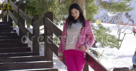 穿着粉色雪衣的女人在楼梯上放松视频的预览图