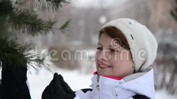 冬天森林里的女人靠近松树视频的预览图