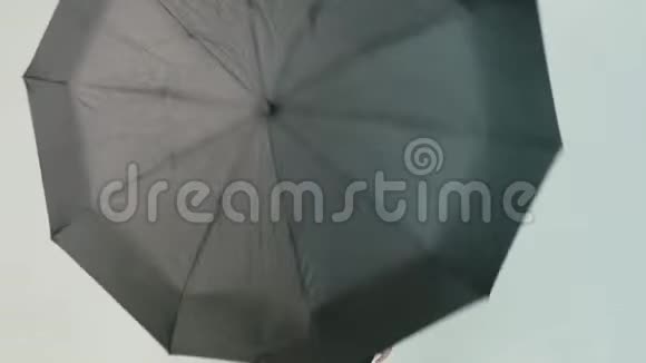 年轻女子在白色背景上打开黑色雨伞视频的预览图