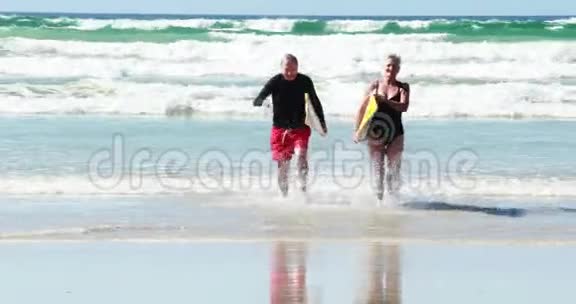 有冲浪板的老夫妇在海滩上视频的预览图
