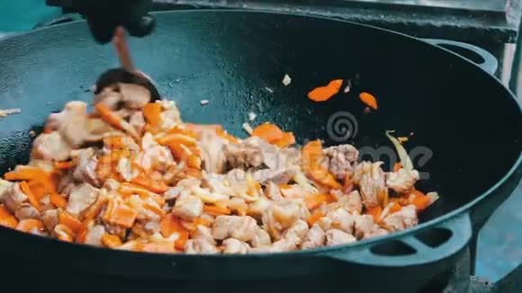 最美味的乌兹别克皮拉夫与胡萝卜米饭和肉是在节日食品场的大浴缸酿造视频的预览图