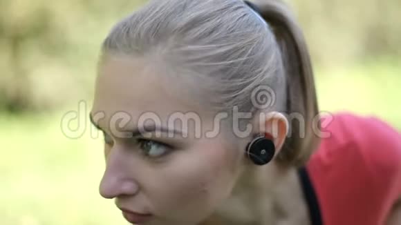 两个带无线耳机的女孩在公园里从事体育活动现代技术的优势视频的预览图