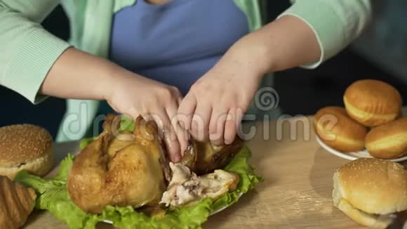 饥饿的女士体重超标吃高脂肪的烤鸡不健康的垃圾食品视频的预览图