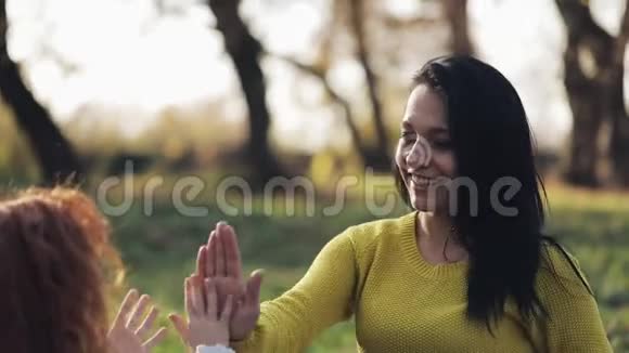 妈妈和女儿手在玩秋天公园的幸福家庭视频的预览图