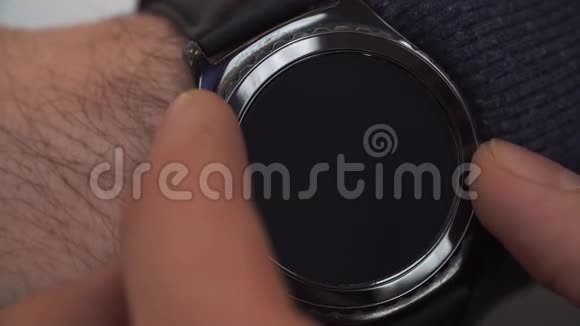 男性手上智能手表的特写在智能手表的显示上练习慢跑准备逃跑的人健身视频的预览图