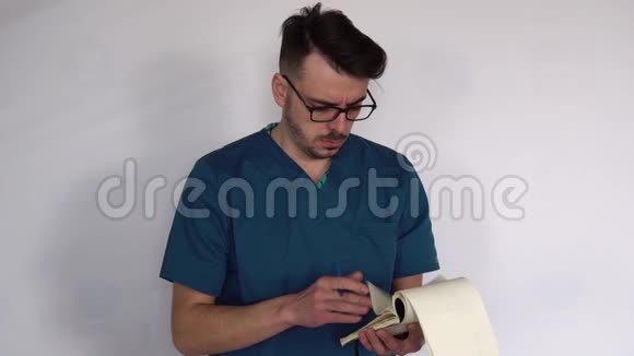 一位戴着眼镜和蓝色实验室外套的年轻医生在克林尼斯特写的笔记本上做笔记视频的预览图
