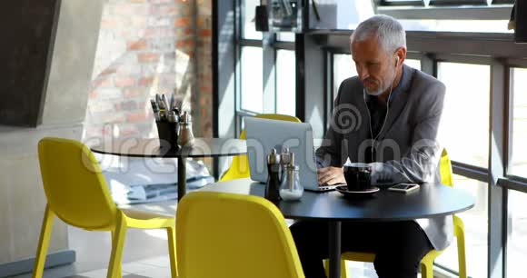 4k酒店的商务人员在使用笔记本电脑时喝咖啡视频的预览图