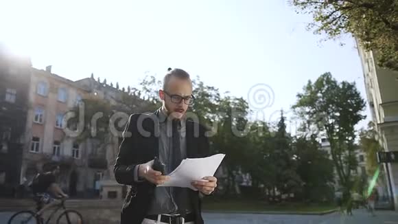 一个戴眼镜的年轻人手里拿着文件视频的预览图