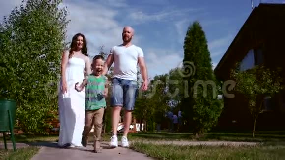 一家人走爱的父母手牵着手孩子到处跑玩得很开心一家人在公园里散步视频的预览图