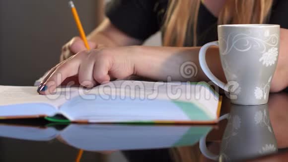 女生写在笔记本上在家里特写视频的预览图