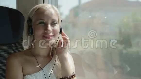 金发在火车上用耳机听音乐视频的预览图
