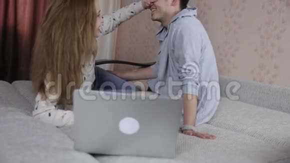 恋爱中的年轻夫妇用笔记本电脑技术家庭电子商务理念视频的预览图