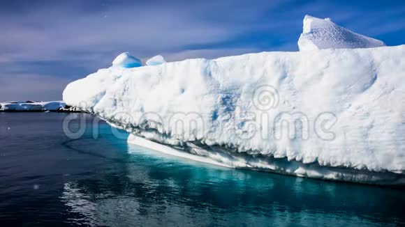 巨大的白色冰冻冰山漂浮在开阔的海洋中视频的预览图