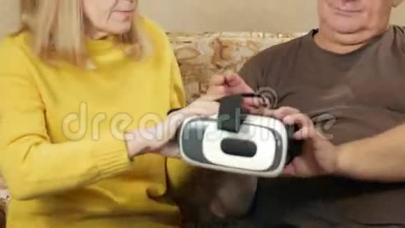 年长夫妇在家尝试眼镜虚拟现实那个人戴着眼镜他们嘲笑正在发生的事情高视频的预览图