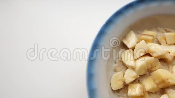 有创意的食物背景健康早餐含牛奶和新鲜香蕉的燕麦粥充满牛奶的燕麦片视频的预览图