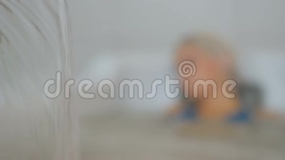 漂亮的女人在浴缸里的泡泡按摩中放松视频的预览图