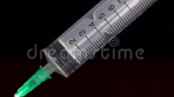 手握一支注射器注射器内充满透明液体在黑色背景上隔离皮下注射器视频的预览图
