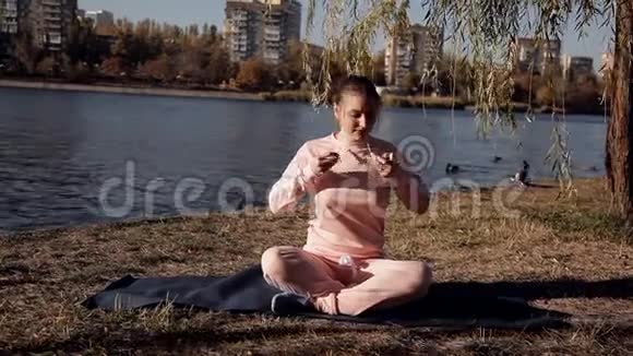 在河边公园里做瑜伽的女孩视频的预览图