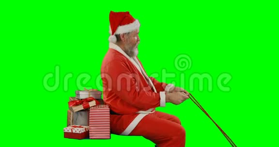 圣诞老人带着礼品盒骑在绿色屏幕上视频的预览图