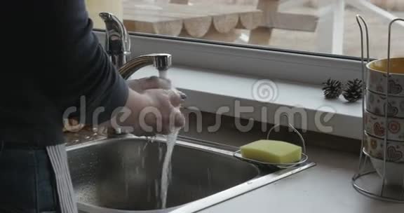 女人的手打开水龙头用冷水彻底清洗漂亮的苹果然后放进盘子里视频的预览图