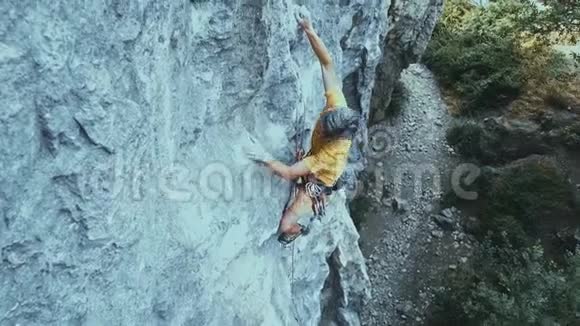 攀岩者开始爬在悬崖上寻找到达和抓住视频的预览图