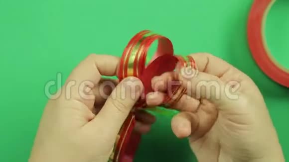 女性双手伸直花瓣的红色丝带礼物弓绿色背景视频的预览图