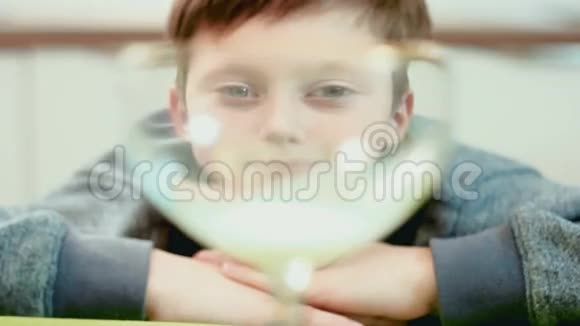 小男孩看着杯子里倒着的牛奶视频的预览图