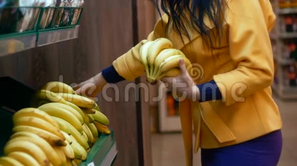 在杂货店生产部挑选香蕉的女人视频的预览图