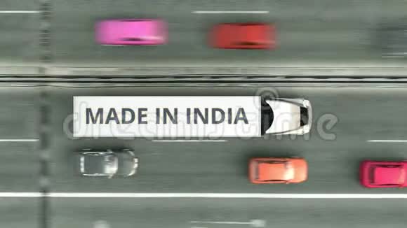高空从上往下看拖车卡车与MADEINDIA文字沿道路行驶与印度商业有关的循环视频的预览图