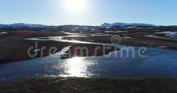 4K无人驾驶飞机在北冰岛日落时从河流上空朝Thjodfell山飞行视频的预览图