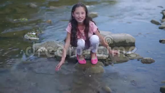 小快乐女孩正在河边玩耍在镜头前探水视频的预览图