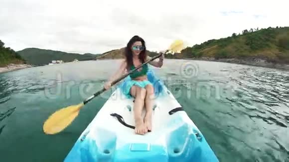戴眼镜的女人在海洋里皮划艇视频的预览图