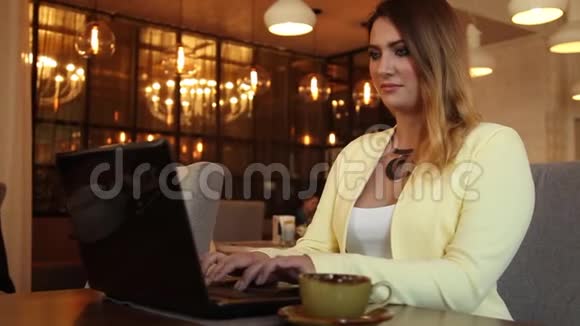 漂亮的商务女性在咖啡馆里用移动电脑工作视频的预览图