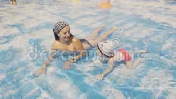 妈妈和女儿在游泳池里爬行视频的预览图