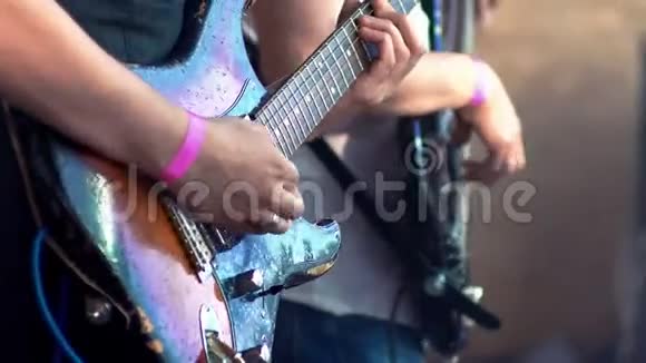 音乐家们在摇滚音乐节上演奏老式电吉他双手特写视频的预览图
