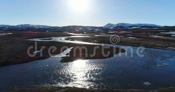 4K无人驾驶飞机在北冰岛日落时从河流上空朝Thjodfell山飞行视频的预览图