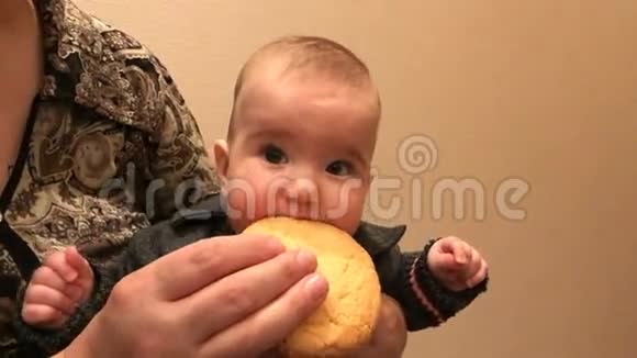 女人抱着一个婴儿她想咬掉饼干视频的预览图