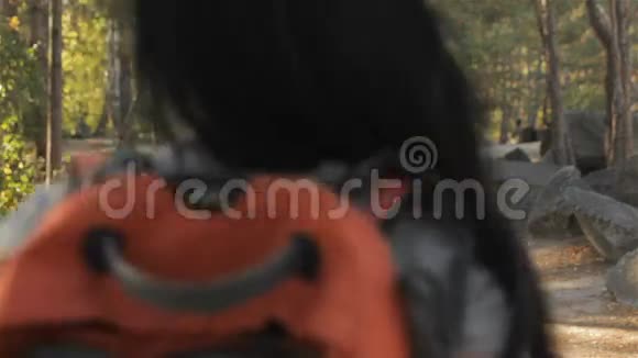 女徒步旅行者在森林里转过身视频的预览图