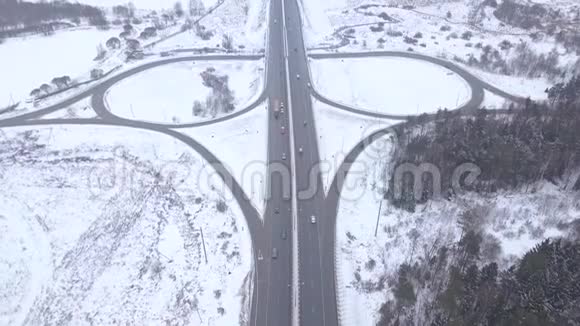 在冬季公路十字路口驾驶的无人视野汽车和卡车视频的预览图