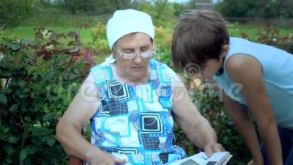 年长的女人给他的孙子读这本书视频的预览图