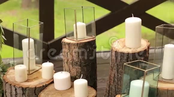 戴着玻璃盒子的蜡烛站在婚礼的原木上视频的预览图