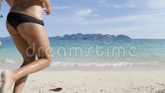 人们在水中奔跑后景年轻人和妇女团体在海滩视频的预览图