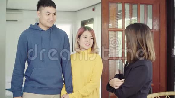 快乐的年轻亚洲夫妇和房地产经纪人开朗的年轻人签署一些文件并与经纪人握手视频的预览图